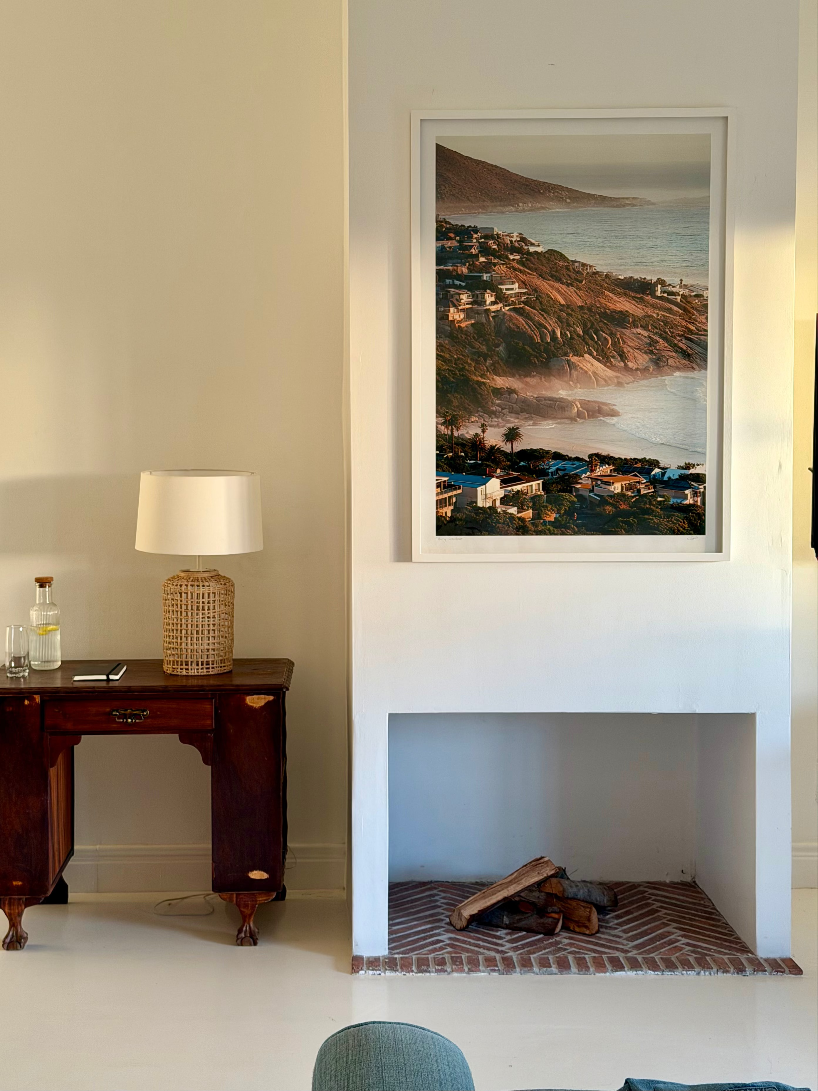 Living room with a fireplace, table, and framed artwork on the wall.