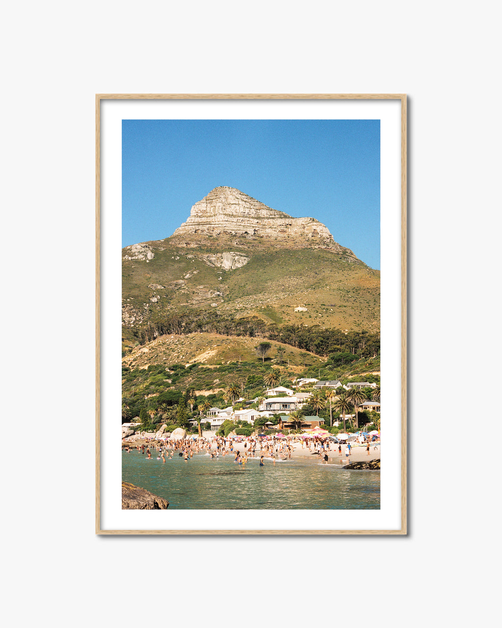 Framed photograph of a coastal scene with a mountain and beach.