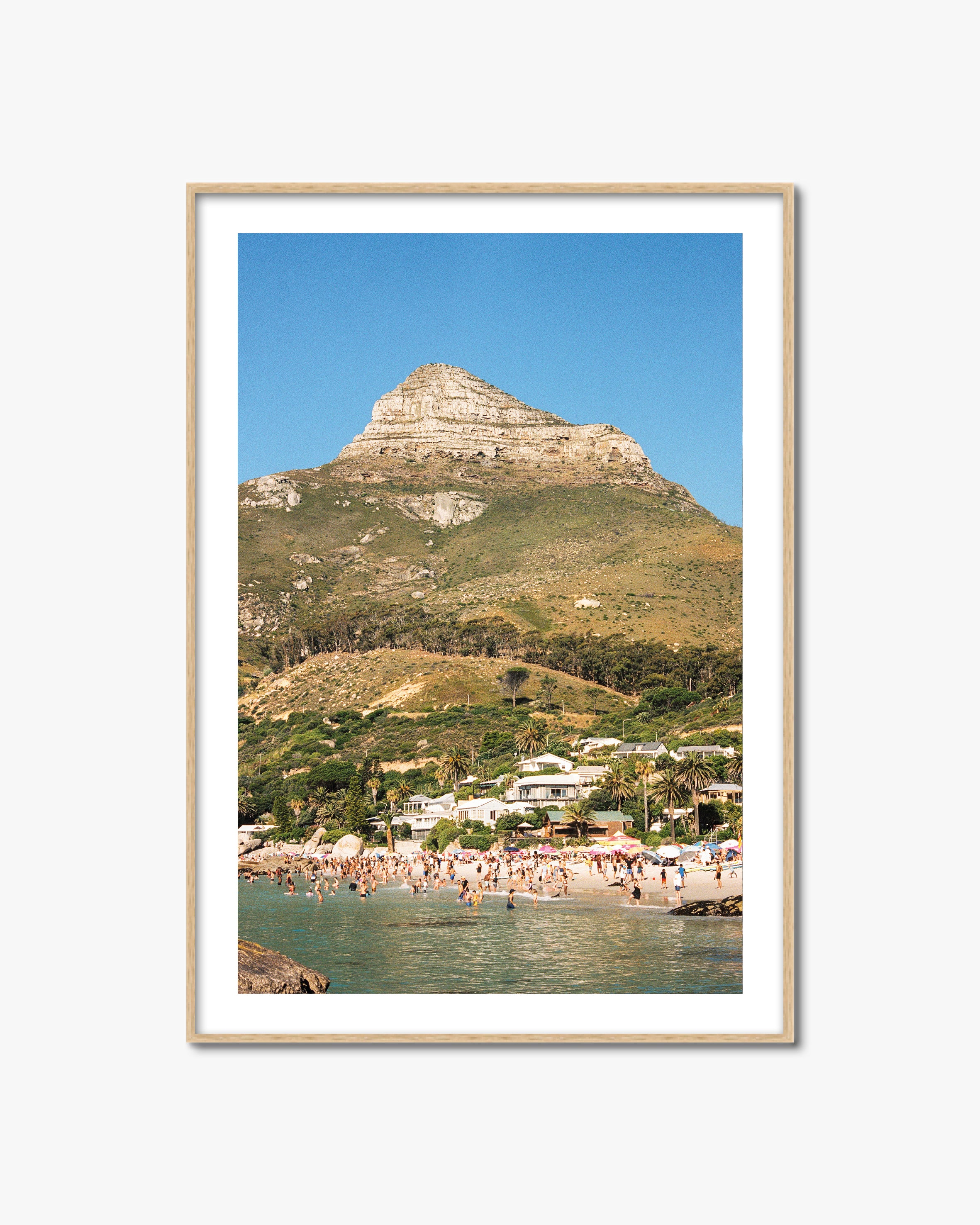 Framed photograph of a coastal scene with a mountain and beach.