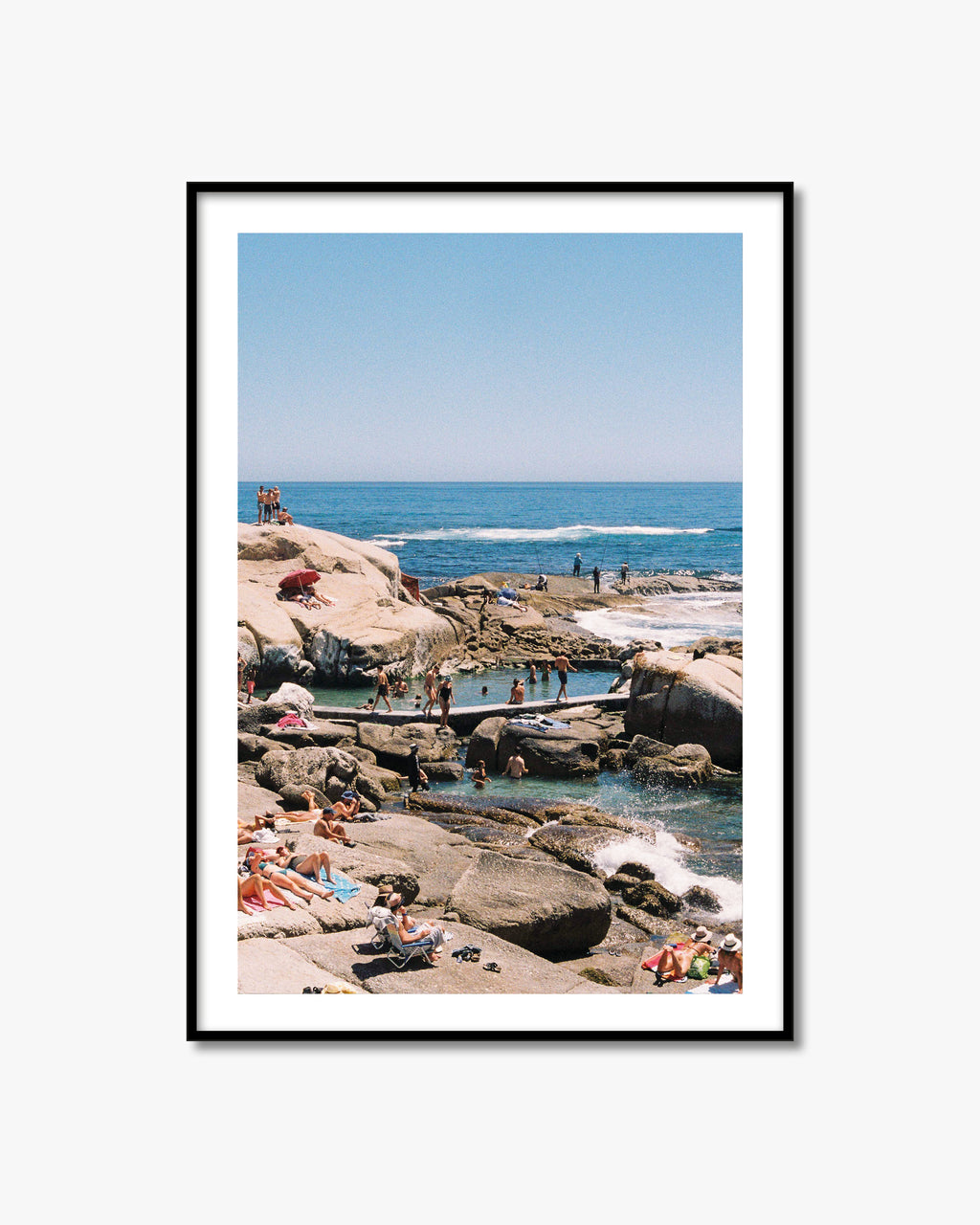 Framed photograph of a beach scene with people enjoying the ocean.