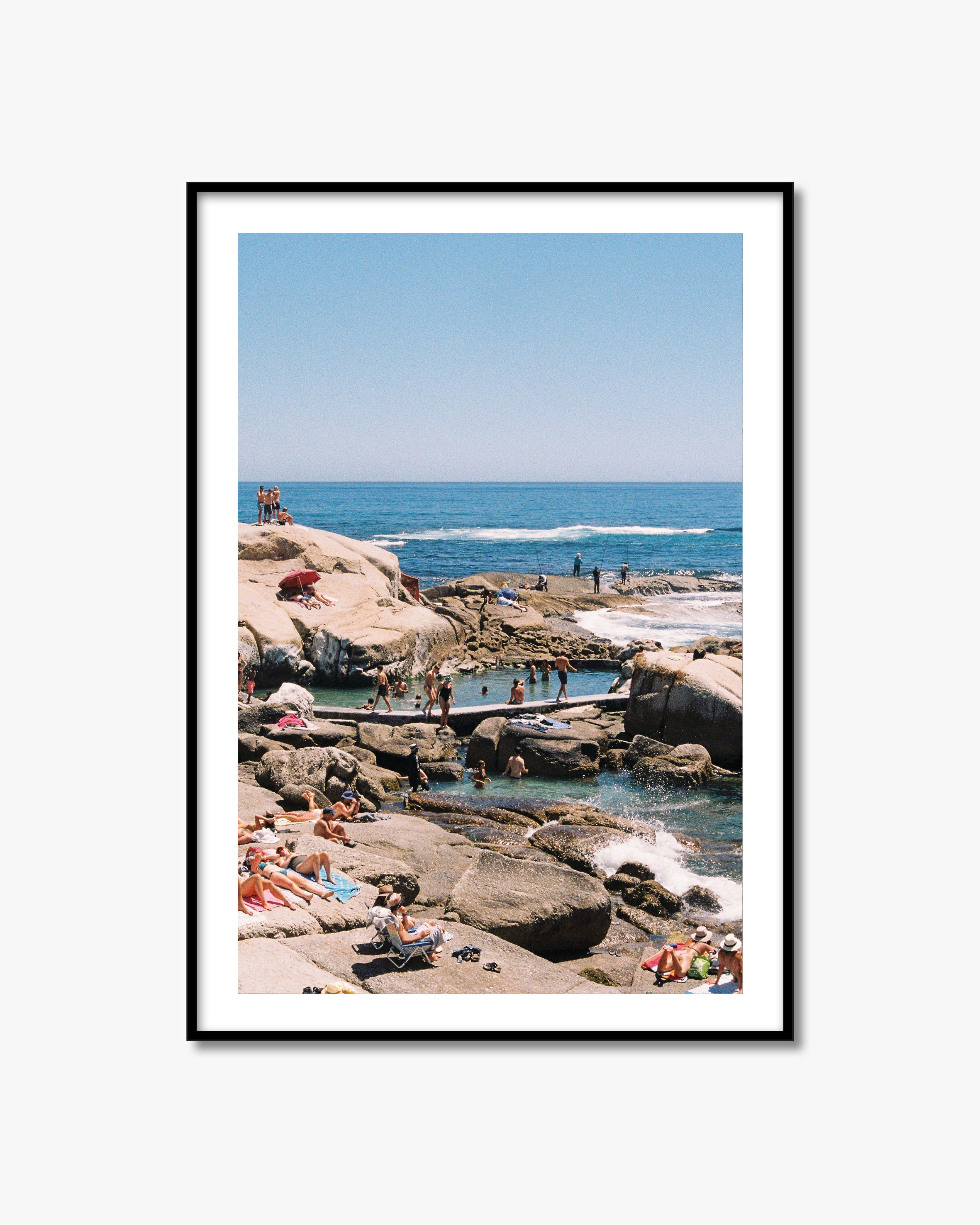 Framed photograph of a beach scene with people enjoying the ocean.