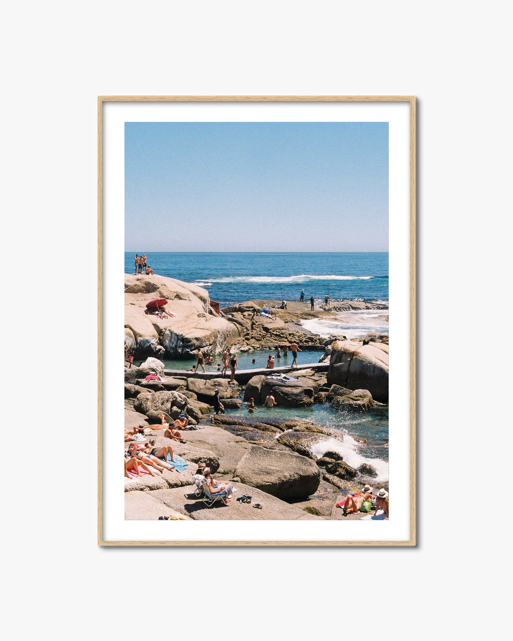 Framed photograph of a beach scene with people enjoying the sun and water.