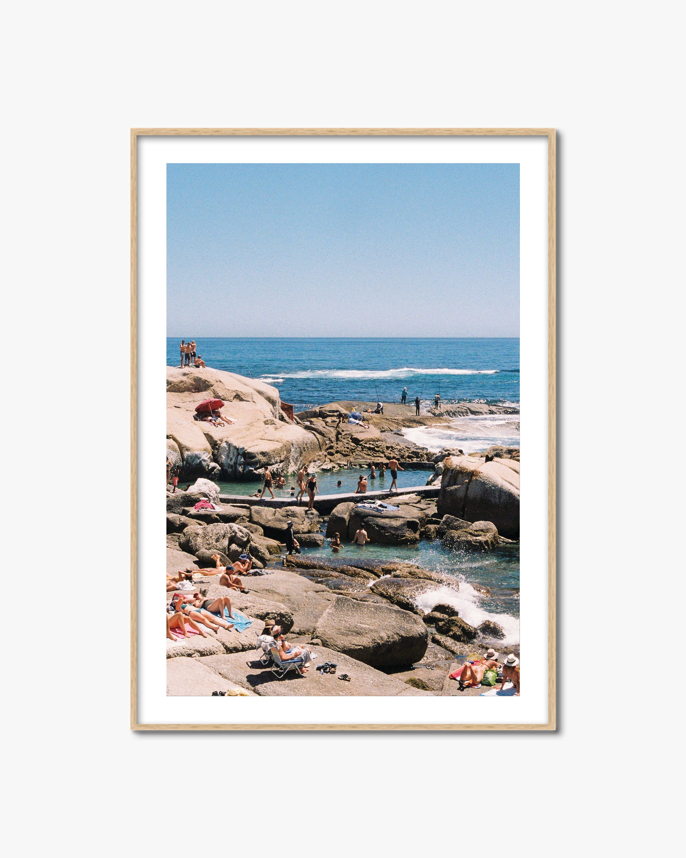 Framed photograph of a beach scene with people enjoying the sun and water.
