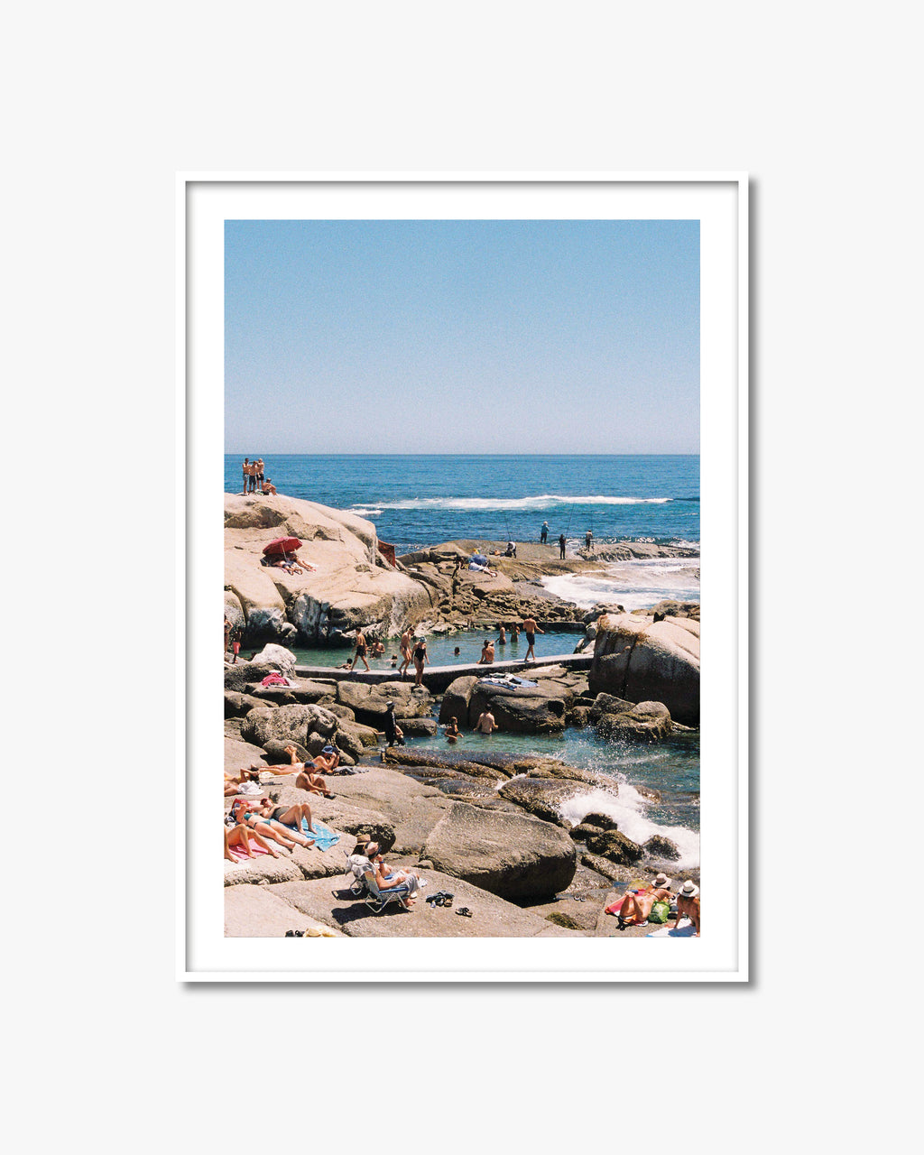Framed photograph of a beach scene with people enjoying the ocean.