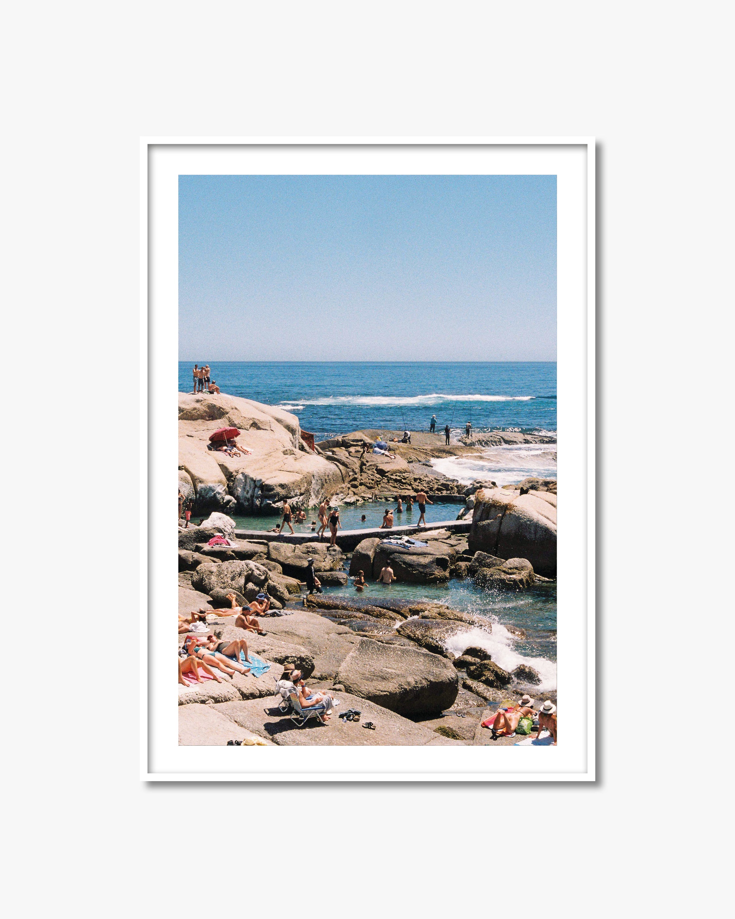 Framed photograph of a beach scene with people enjoying the ocean.
