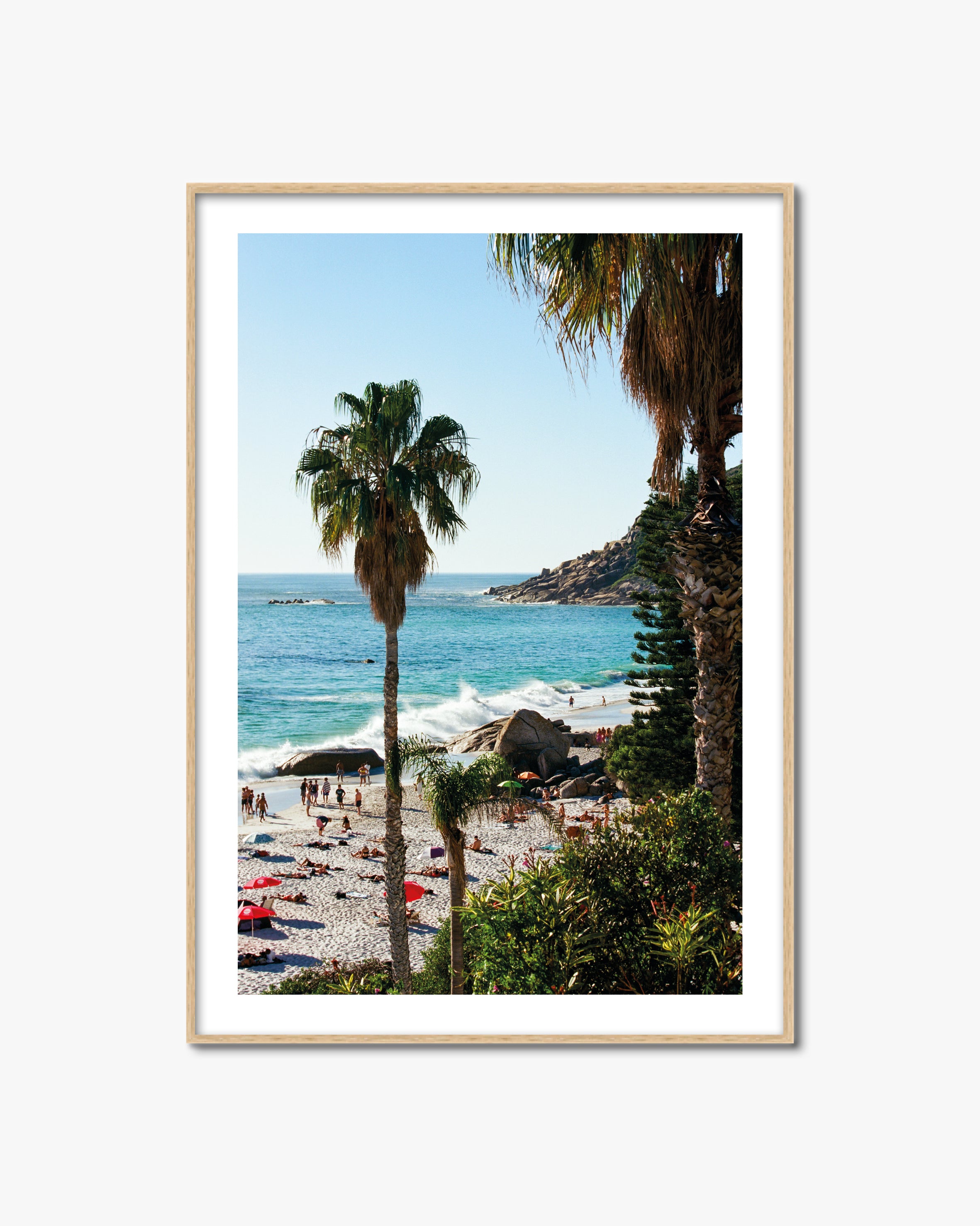 Framed artwork of a beach scene with palm trees and turquoise water.